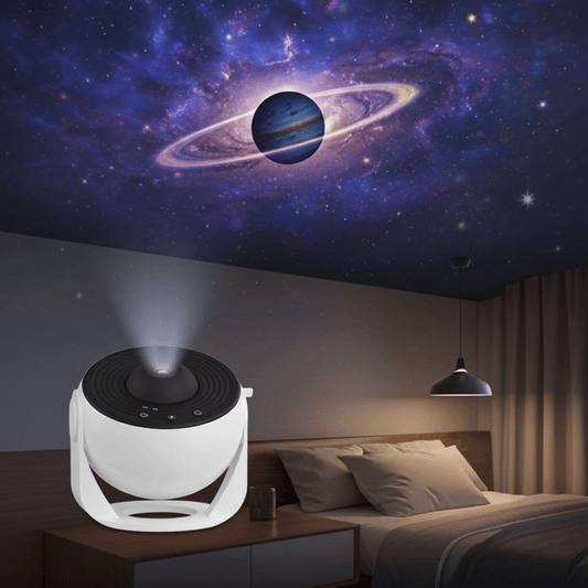 A white and black portable projector shown in a bedroom setting, projecting a colorful galaxy and Saturn scene onto the ceiling above a bed.