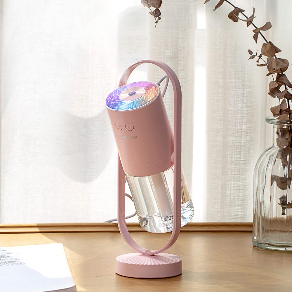Portable pink smart home oil diffuser and desktop humidifier with integrated color-changing light.