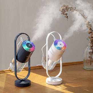 Portable smart aromatherapy humidifier and oil diffuser with colorful light effect and adjustable stand.