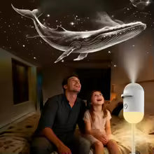 Man and child watching a whale projected onto a ceiling with a small lamp emitting light.
