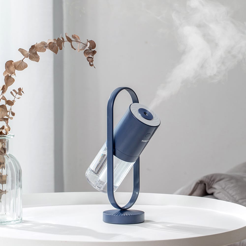 Portable smart home ultrasonic humidifier and mist diffuser in dark blue with transparent water tank.