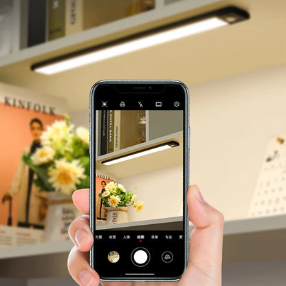 Person taking a photo of a bookshelf with a smartphone in a store setting.